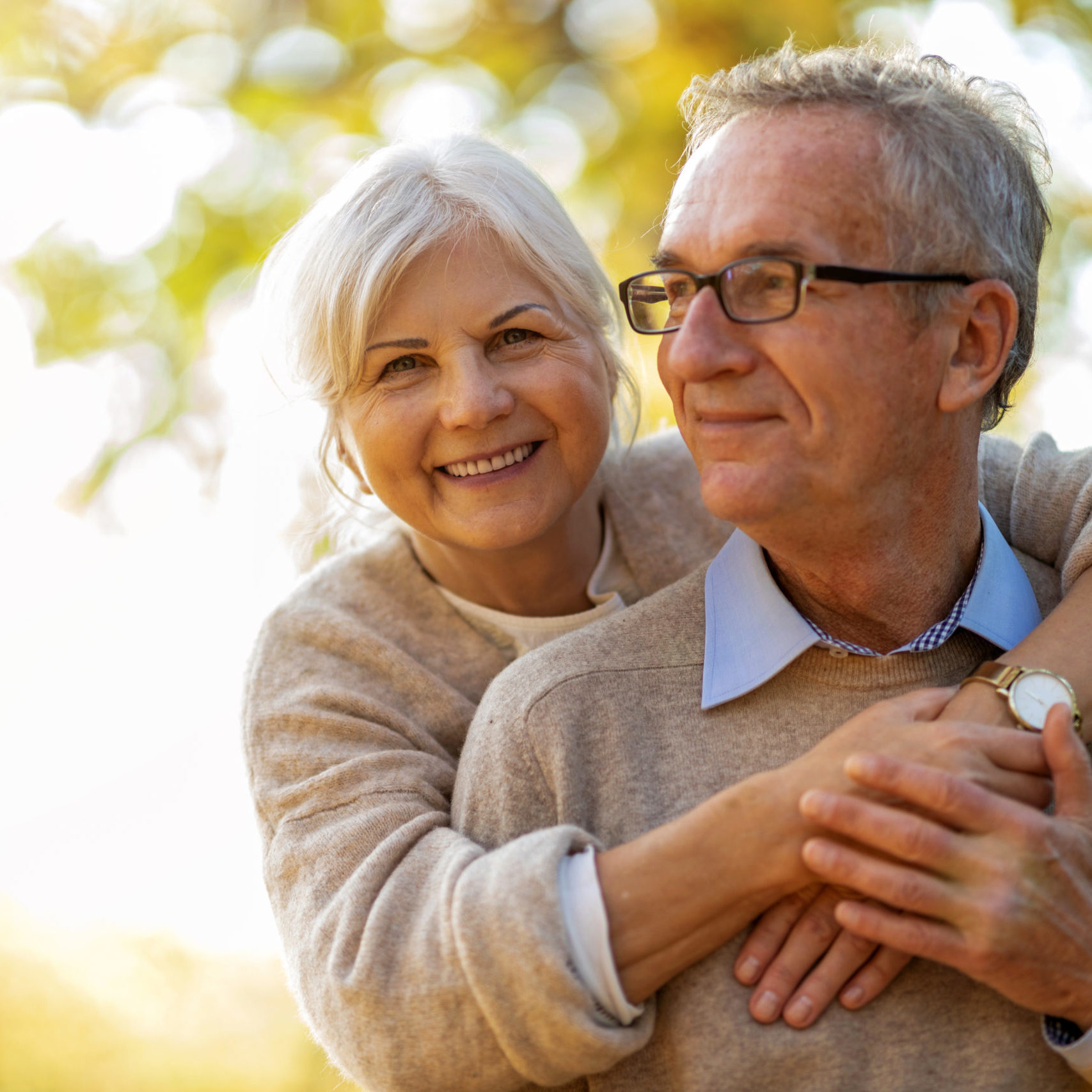 Elderly couple embracing in autumn park